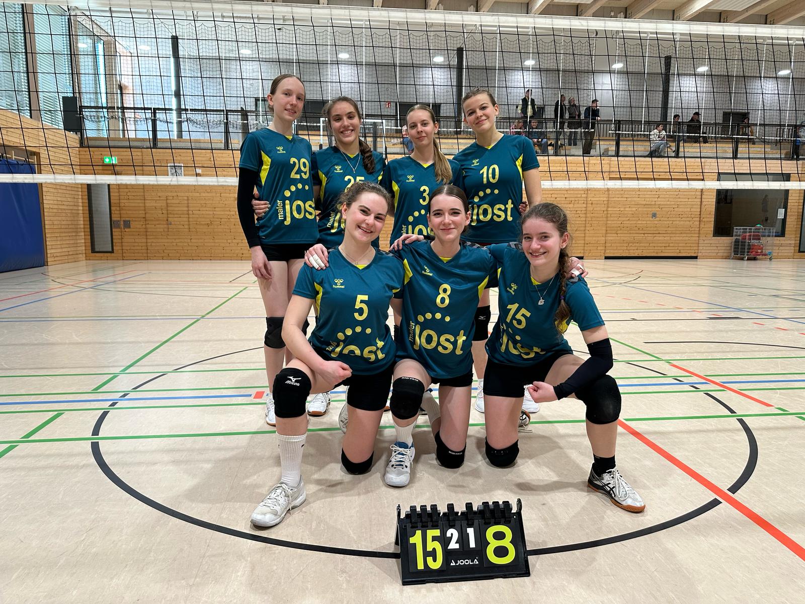 U20 Volleyball weiblich Mannschaftsbild vor dem Netz. 4 Spielerinnen stehend, 3 kniend.